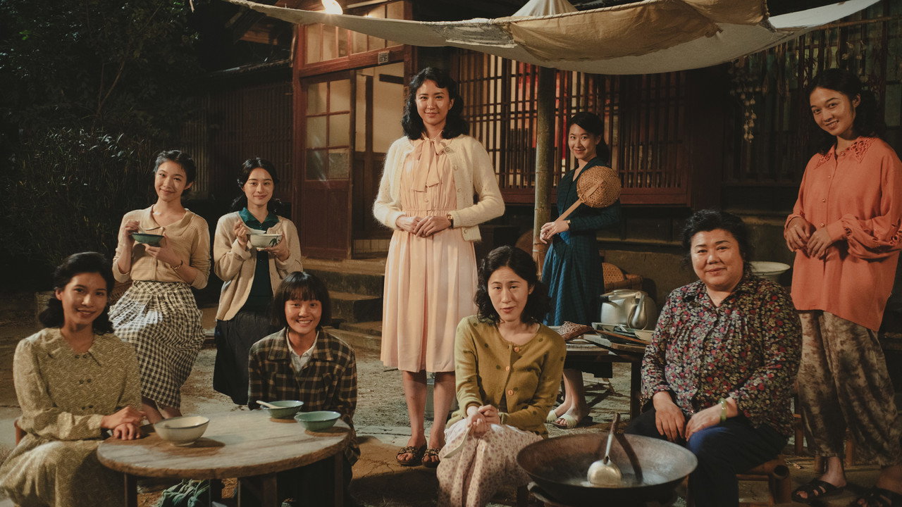 《大濛》入夜的院子裡一群女性圍著桌子合影